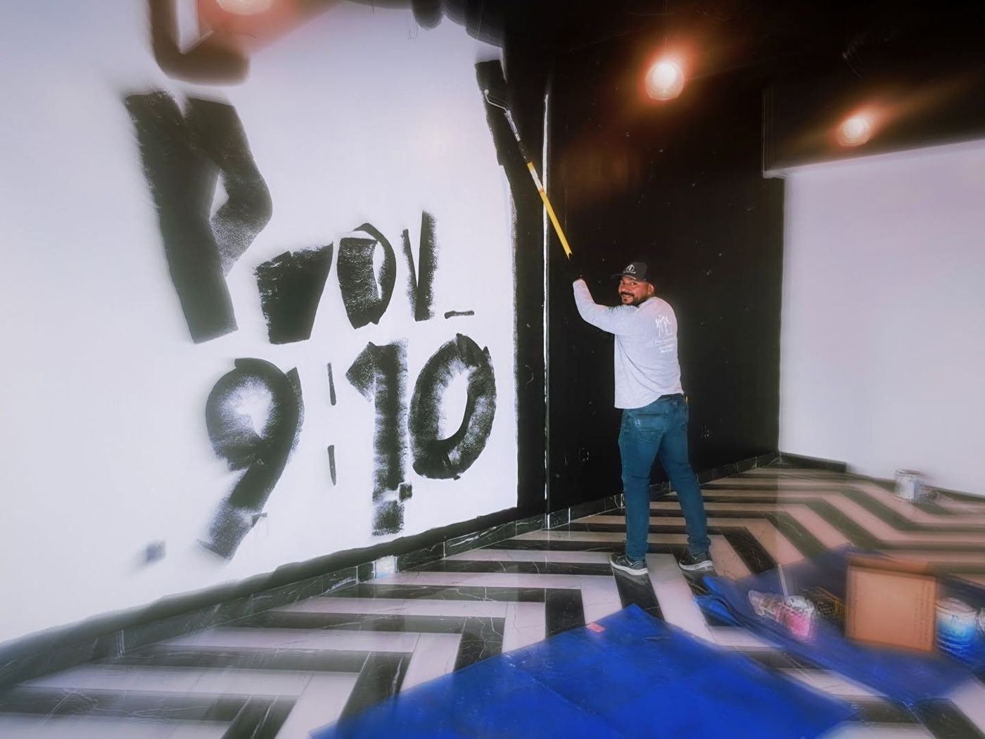 Marvin Contreras painting a Proverbs 9:10 wall mural